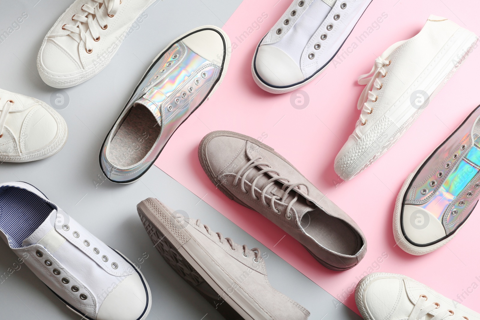 Photo of Flat lay composition with different sneakers on color background