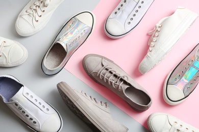 Photo of Flat lay composition with different sneakers on color background