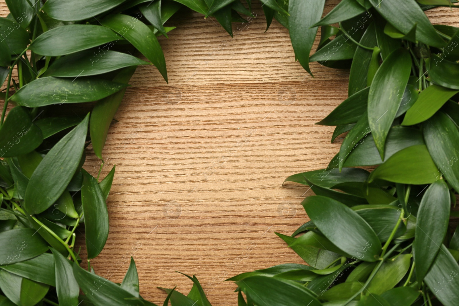 Photo of Beautiful handmade mistletoe wreath on wooden table, top view. Space for text