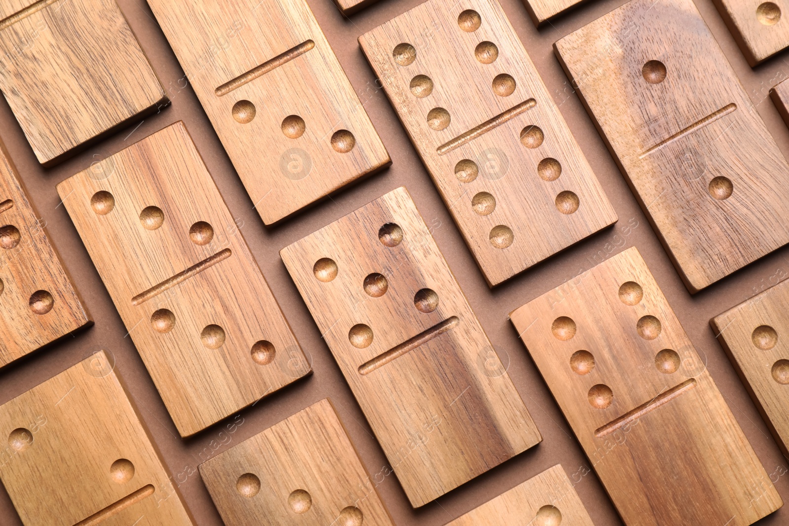 Photo of Set of wooden domino tiles on brown background, flat lay