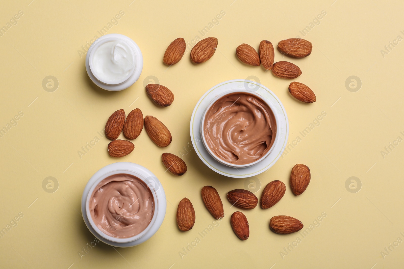 Photo of Flat lay composition with jars of body cream on beige background