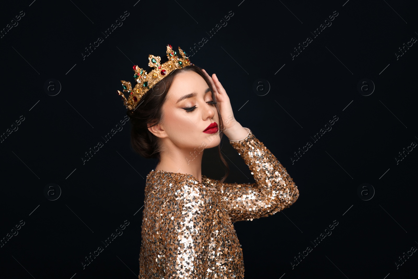 Photo of Beautiful young woman wearing luxurious crown on black background