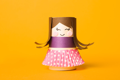 Photo of Toy doll made of toilet paper hub on yellow background