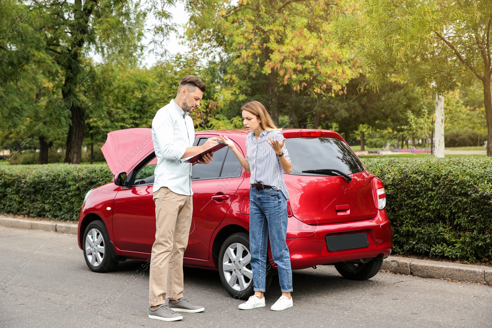 Photo of People near red broken car on street