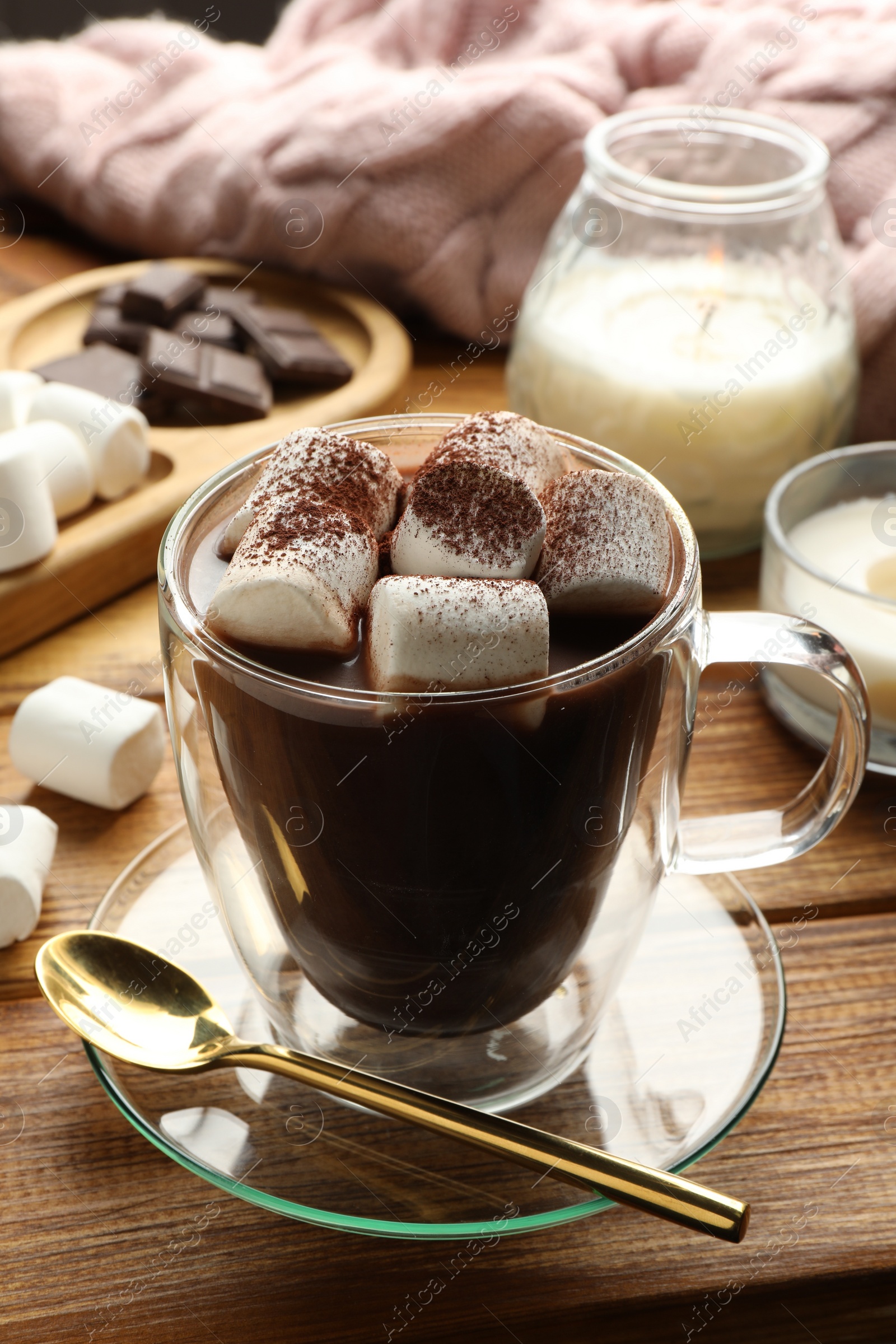 Photo of Cup of aromatic hot chocolate with marshmallows and cocoa powder served on wooden table, closeup