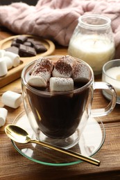 Photo of Cup of aromatic hot chocolate with marshmallows and cocoa powder served on wooden table, closeup