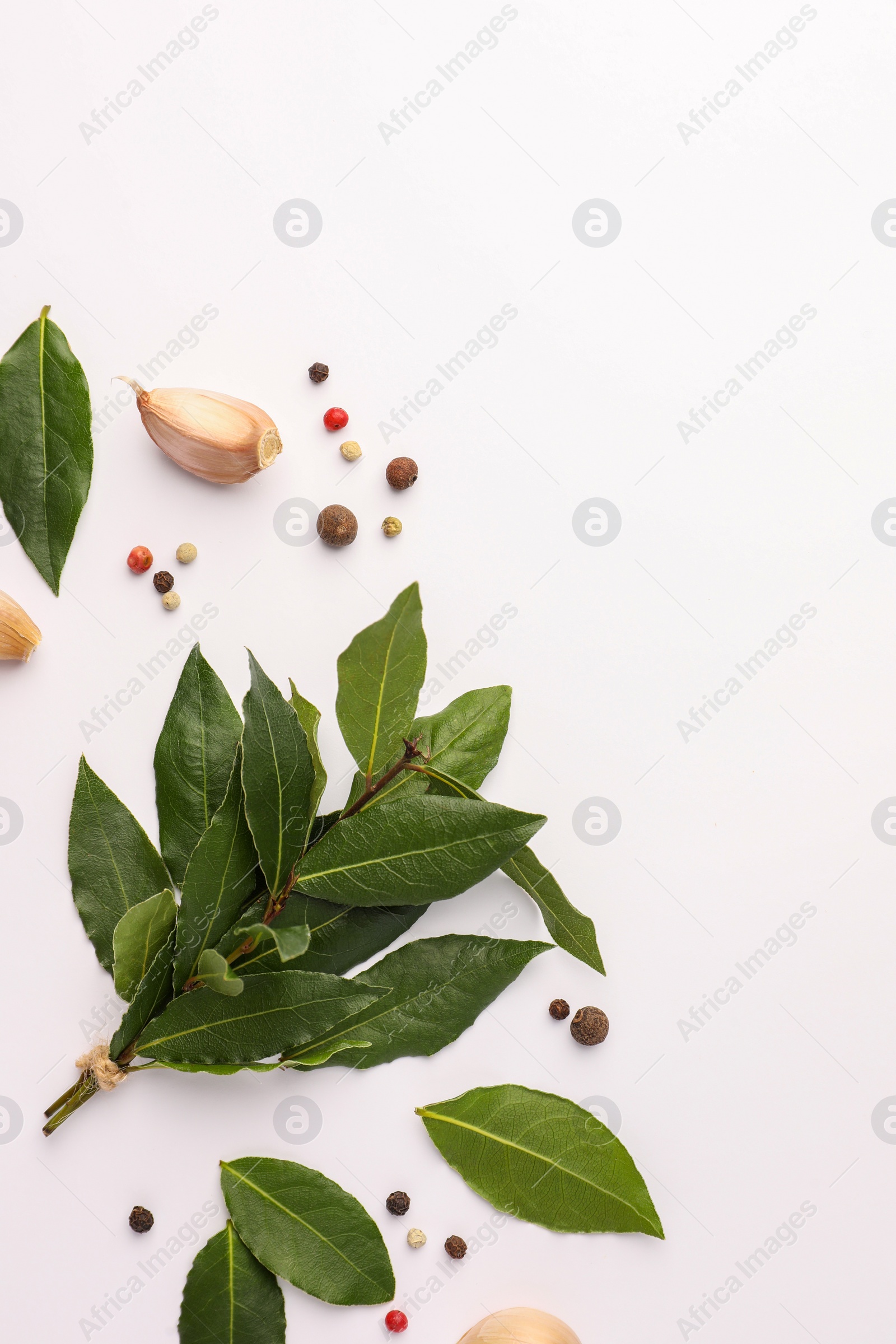 Photo of Aromatic bay leaves and spices on white background, flat lay. Space for text