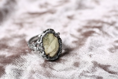 Beautiful silver ring with prehnite gemstone on light fabric, closeup