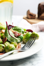 Delicious Brussels sprouts with bacon on table, closeup