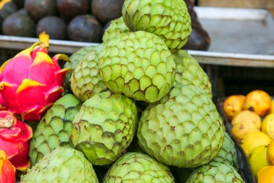 Photo of Cherimoya and dragon fruit at market, closeup