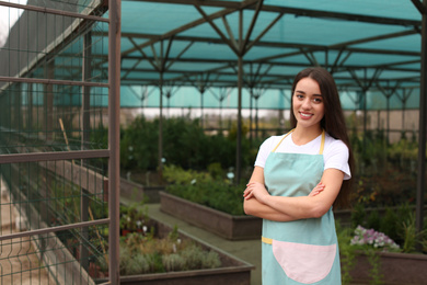 Female business owner in greenhouse. Space for text