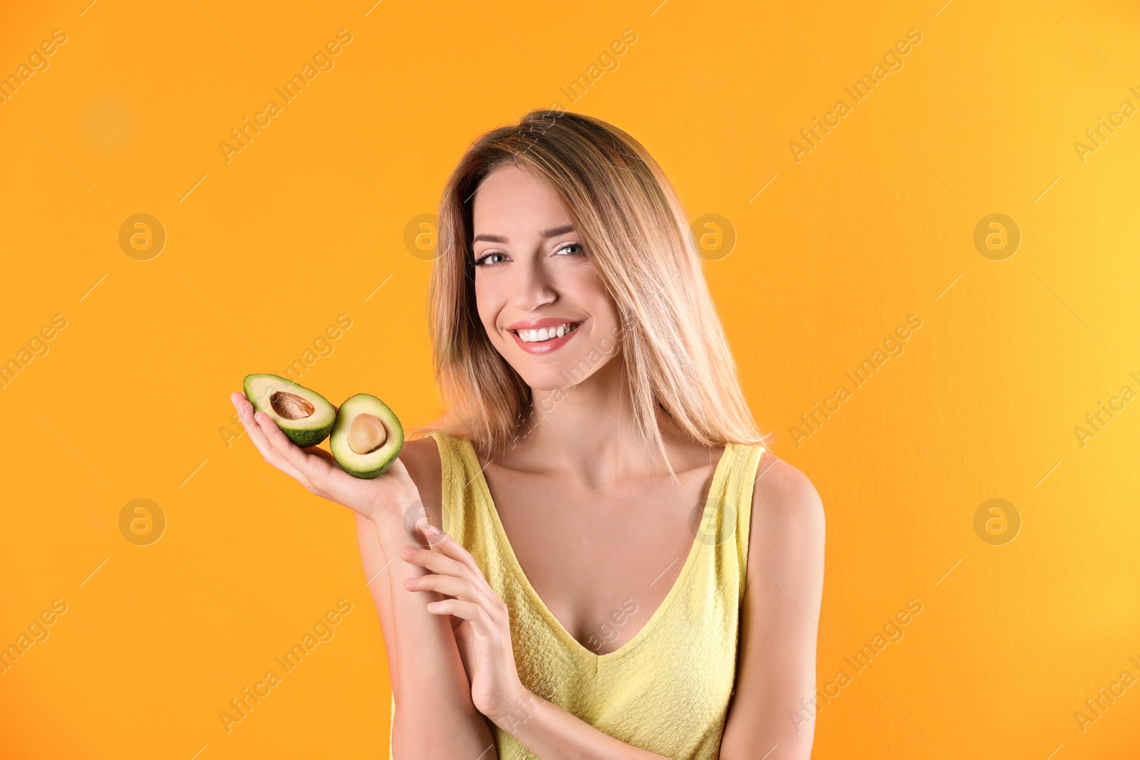 Photo of Portrait of young beautiful woman with ripe delicious avocado on color background