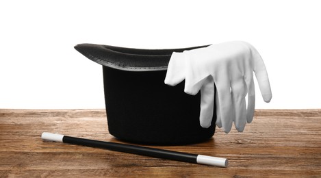 Photo of Magician's hat, gloves and wand on wooden table against white background