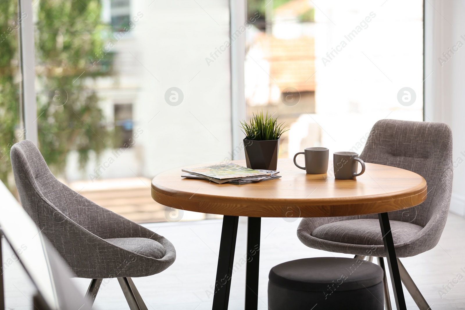 Photo of Stylish room interior with round table and comfortable chairs