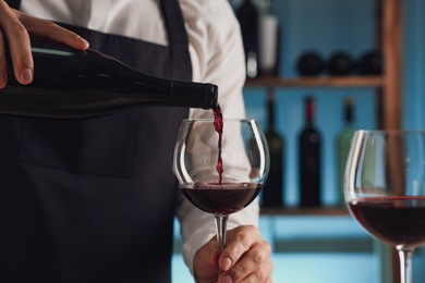 Bartender pouring wine into glass in restaurant, closeup