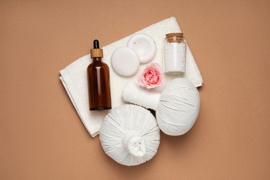 Photo of Flat lay composition of herbal bags and spa products on light brown background