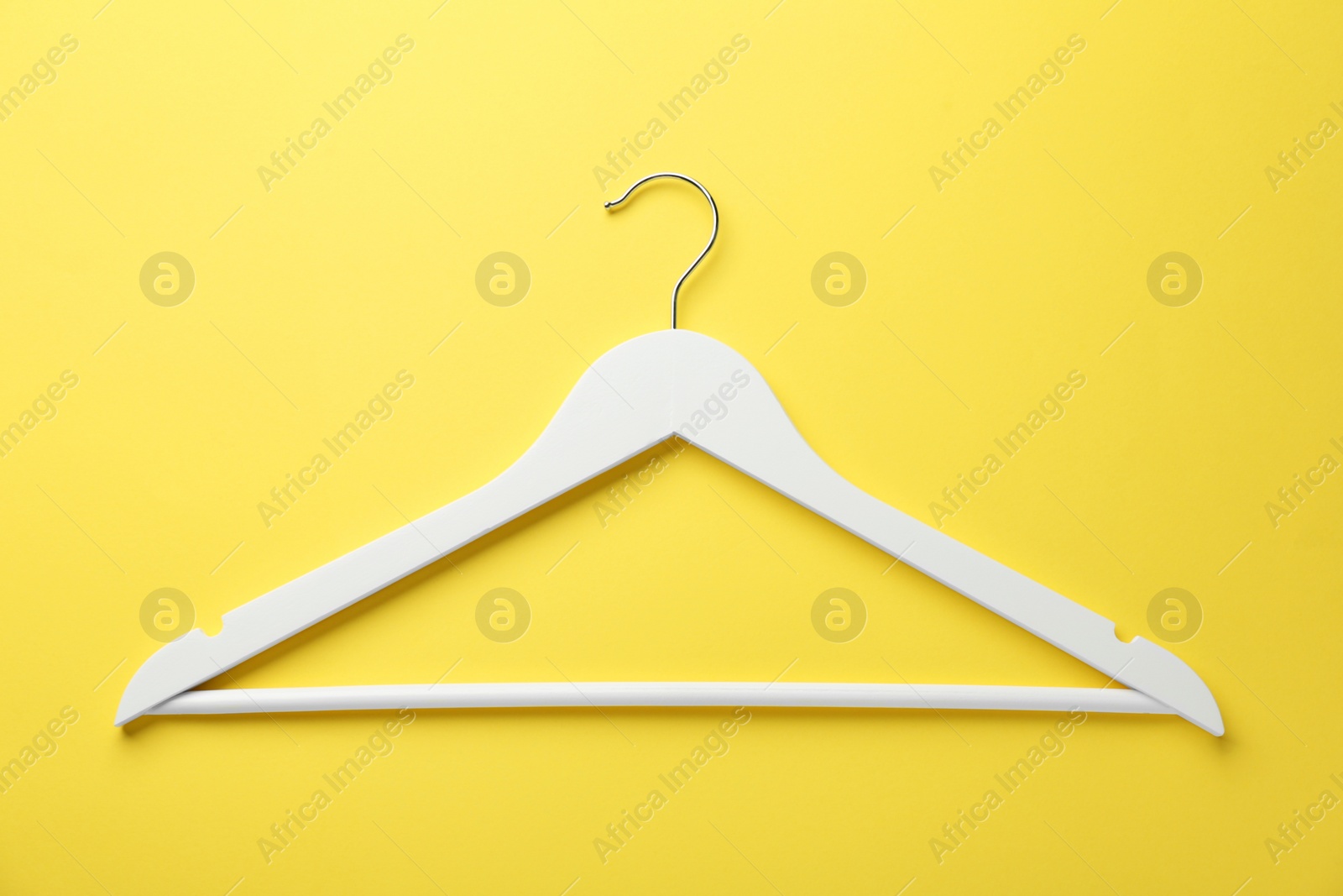 Photo of White hanger on yellow background, top view