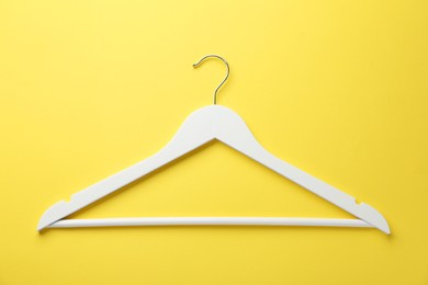 White hanger on yellow background, top view