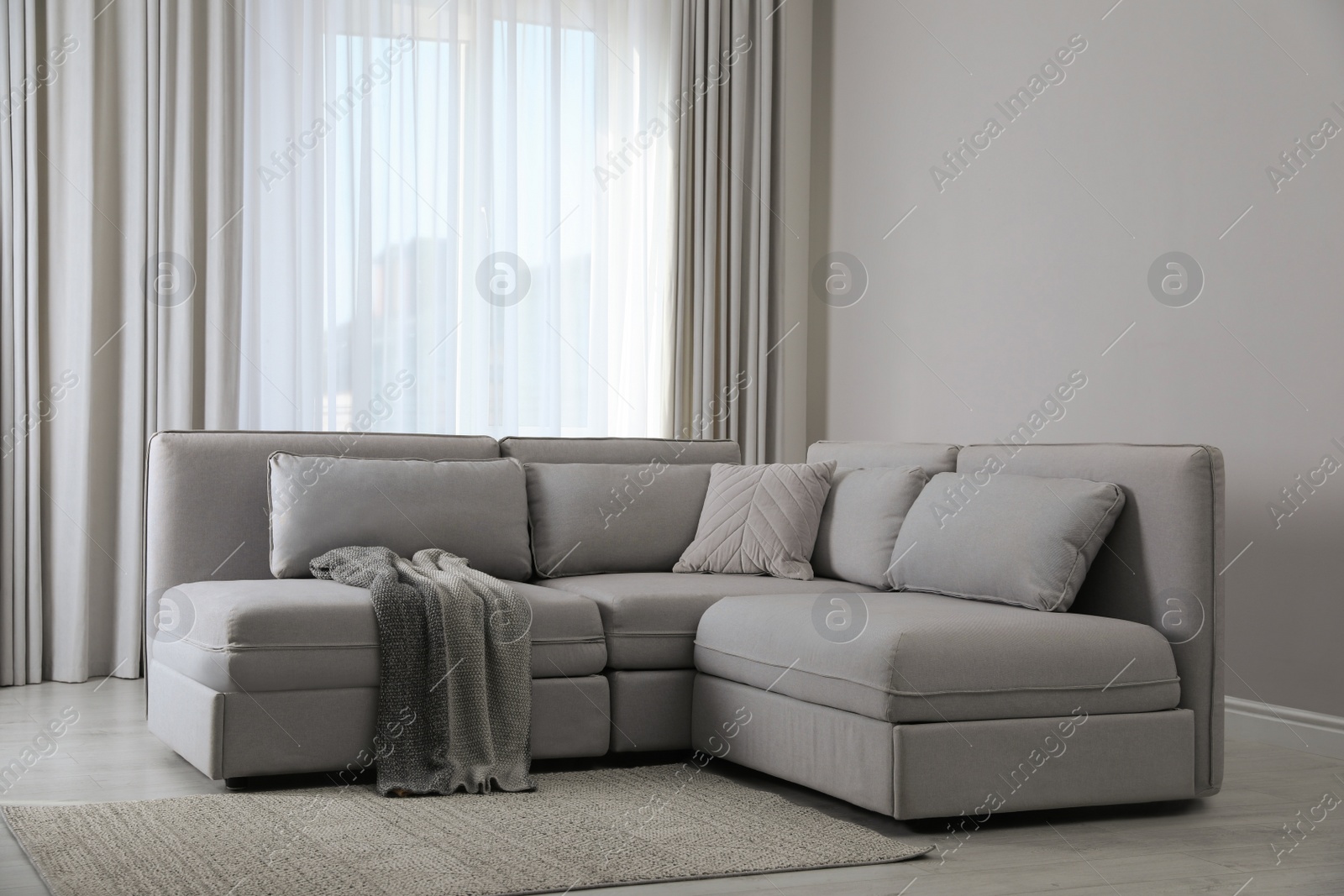 Photo of Large grey sofa in living room. Interior design