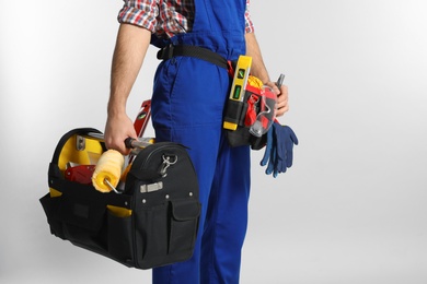Photo of Construction worker with set of tools on light background, closeup. Space for text