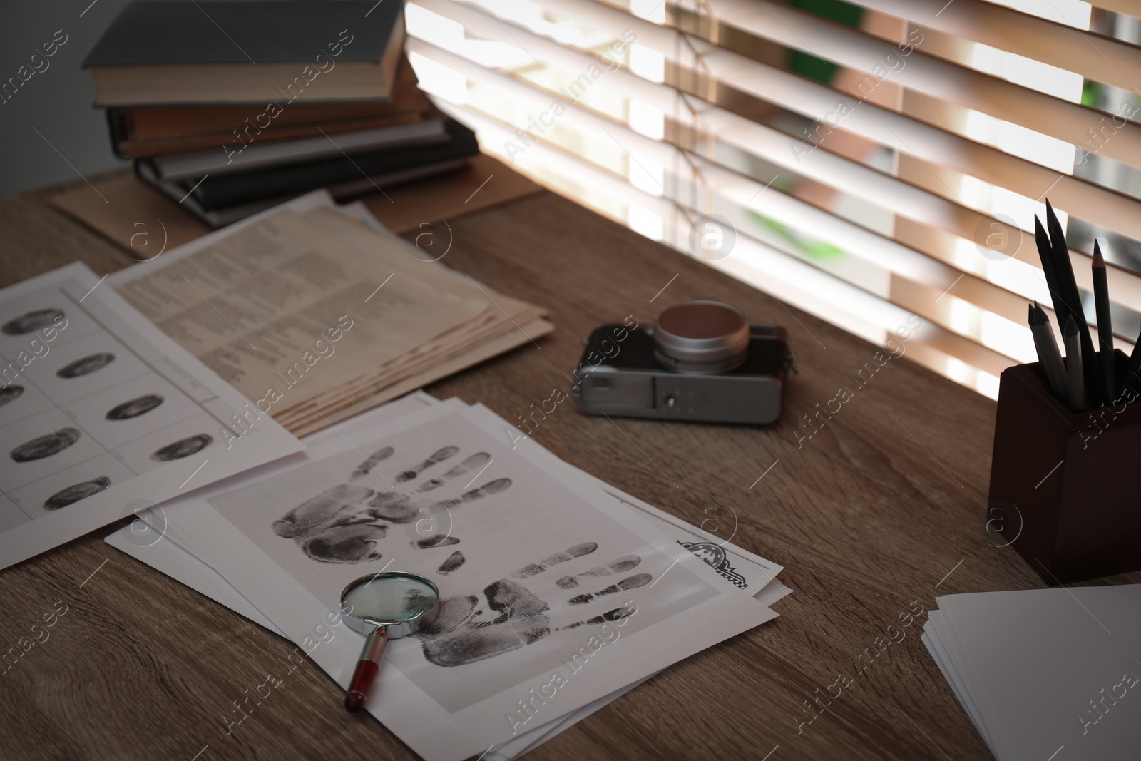 Photo of Fingerprints and papers on desk in office. Detective's workplace