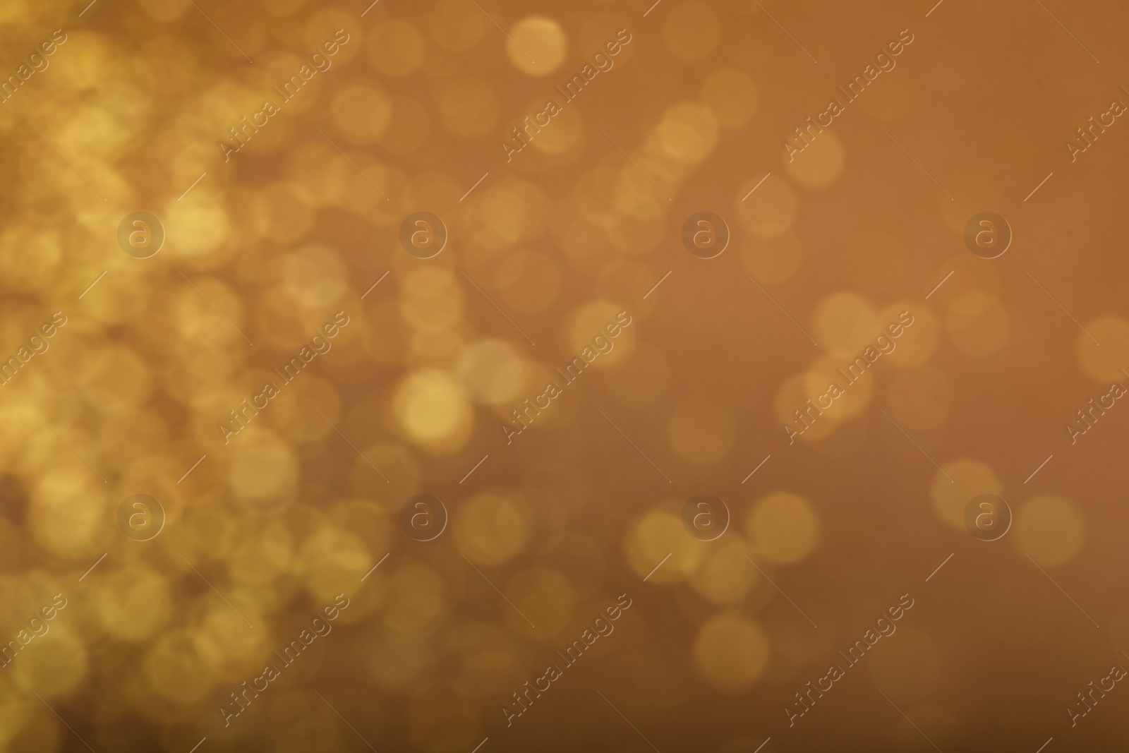 Photo of Blurred view of golden lights on brown background. Bokeh effect