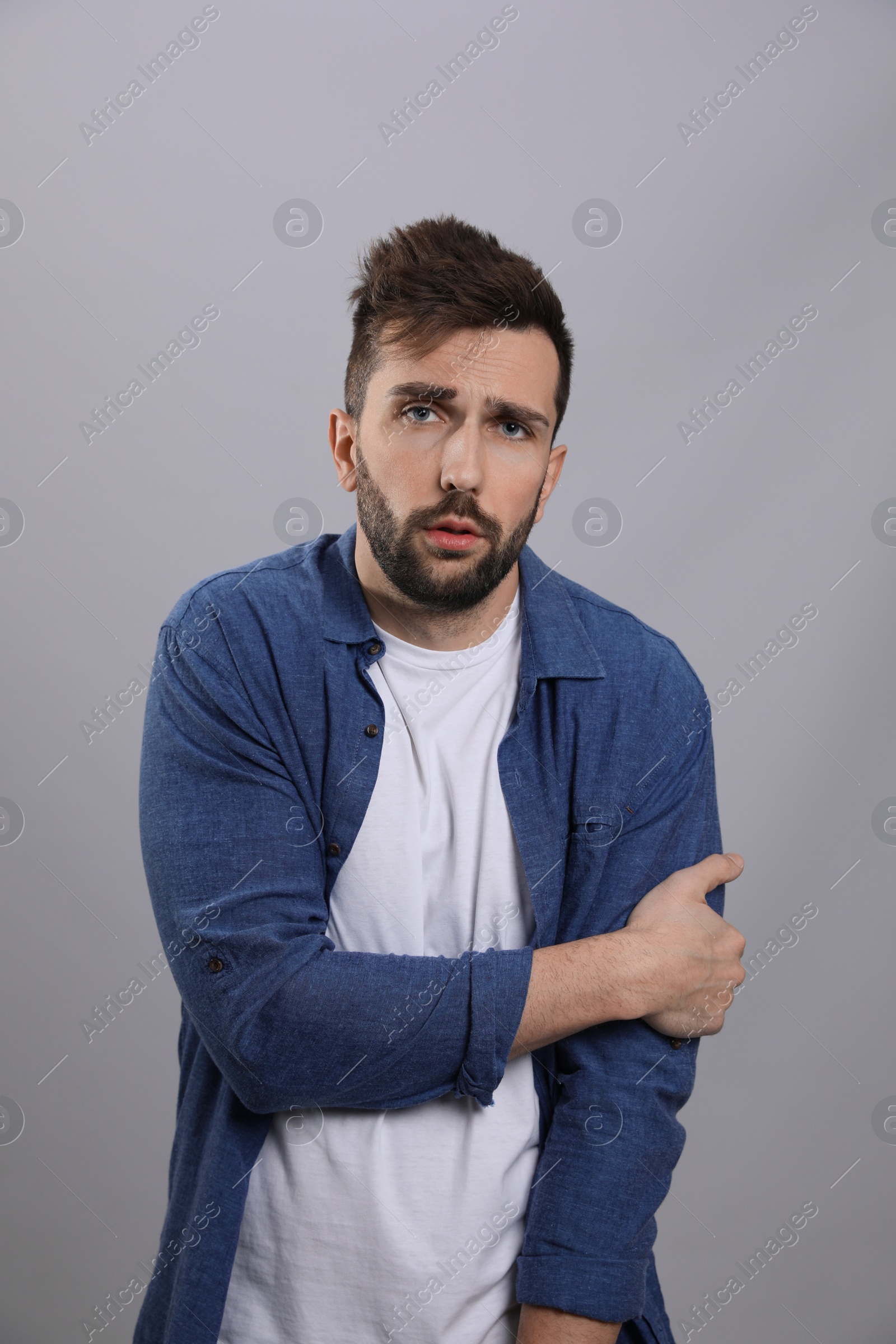 Photo of Man suffering from fever on grey background. Cold symptoms