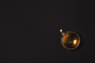 Photo of Diwali diya or clay lamp on dark background, top view