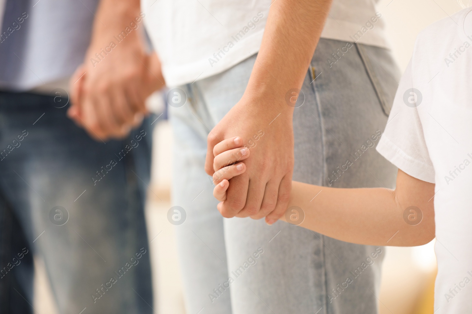 Photo of Happy family holding hands indoors, closeup view