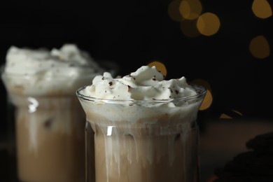 Glasses of iced coffee against blurred lights, closeup