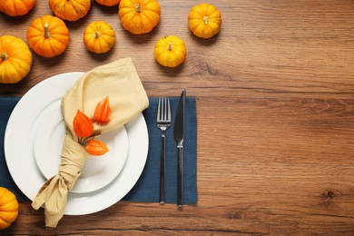 Photo of Stylish autumn table setting on wooden background, flat lay. Space for text