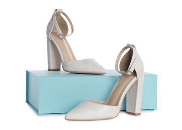 Photo of Pair of stylish shoes and turquoise box on white background
