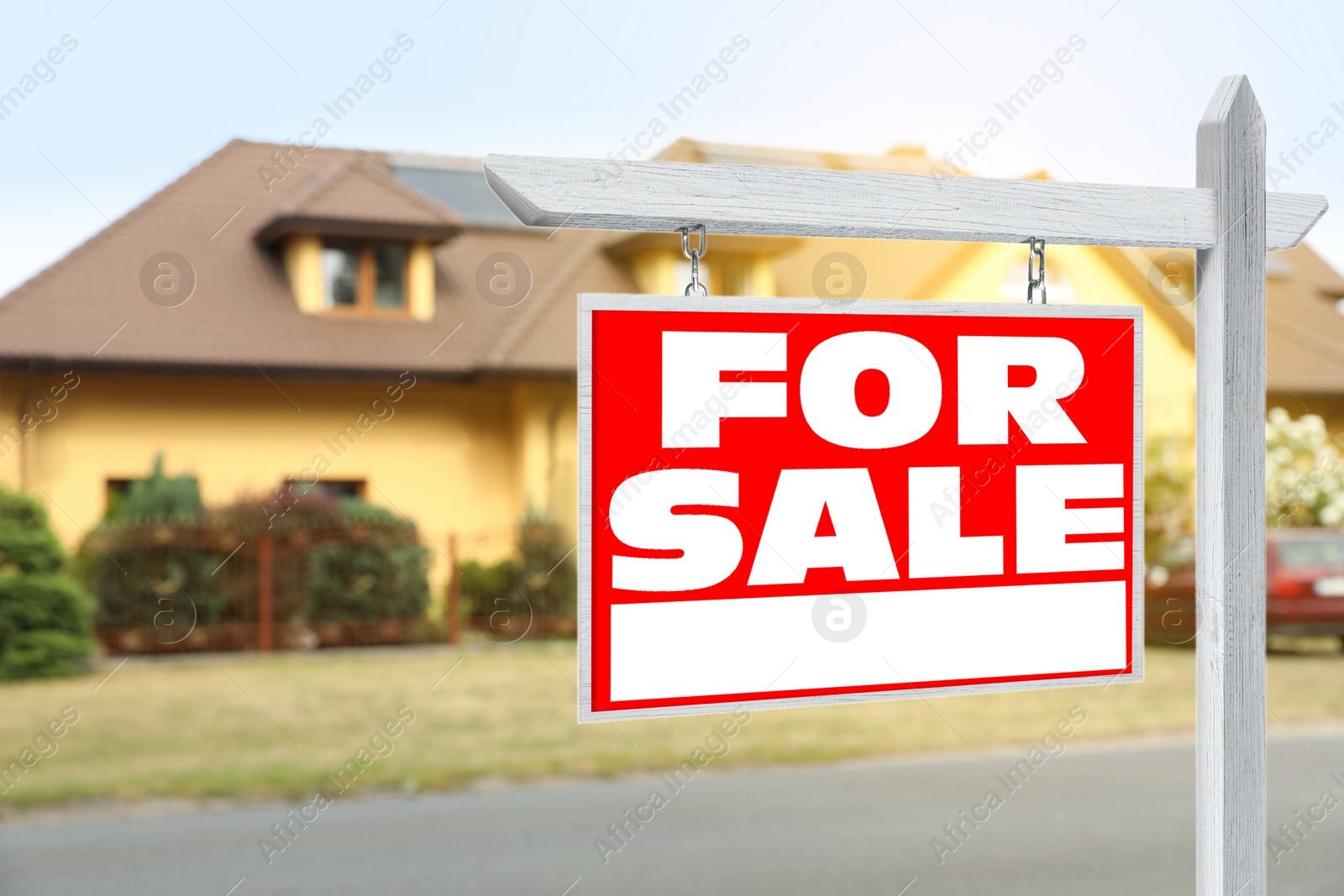 Image of Sale sign near beautiful house outdoors. Red signboard with words