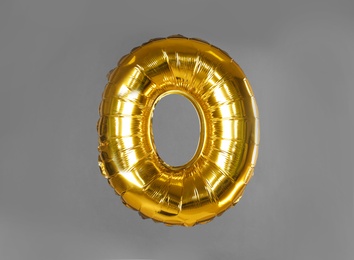 Photo of Golden letter O balloon on grey background