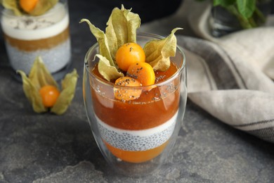 Delicious dessert decorated with physalis on grey table