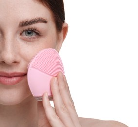 Washing face. Young woman with cleansing brush on white background, closeup