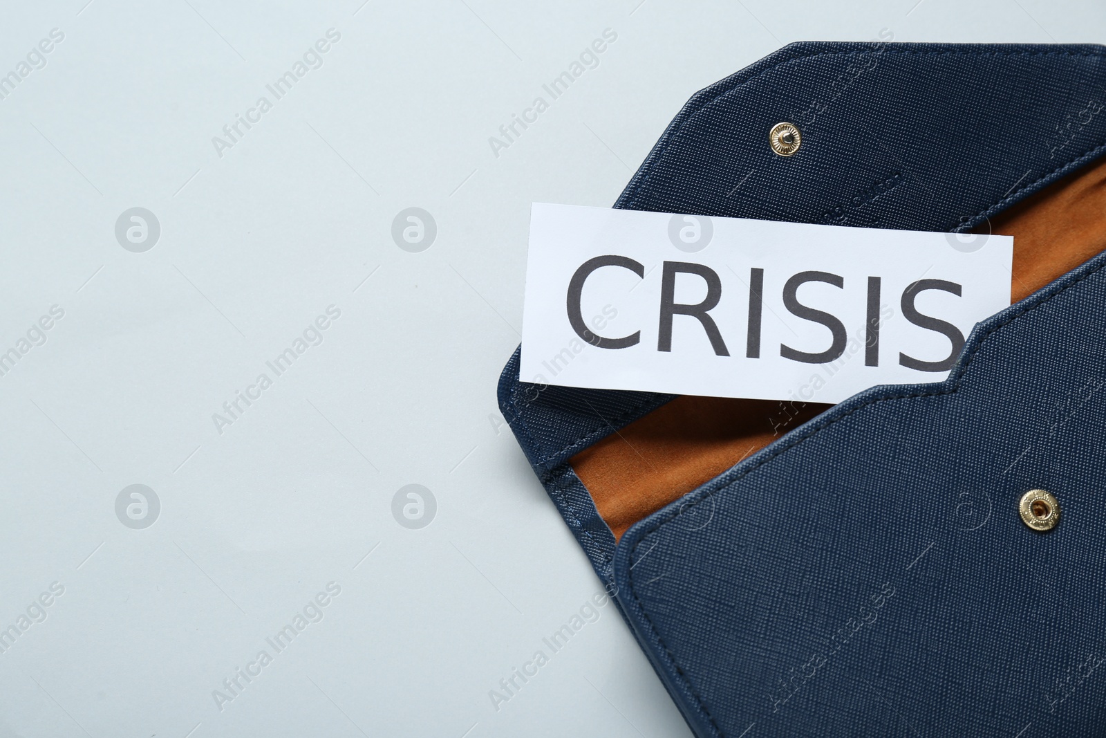 Photo of Purse with word Crisis on white background, above view. Space for text