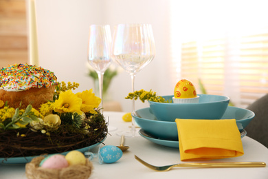 Photo of Festive Easter table setting with beautiful floral decor and eggs indoors