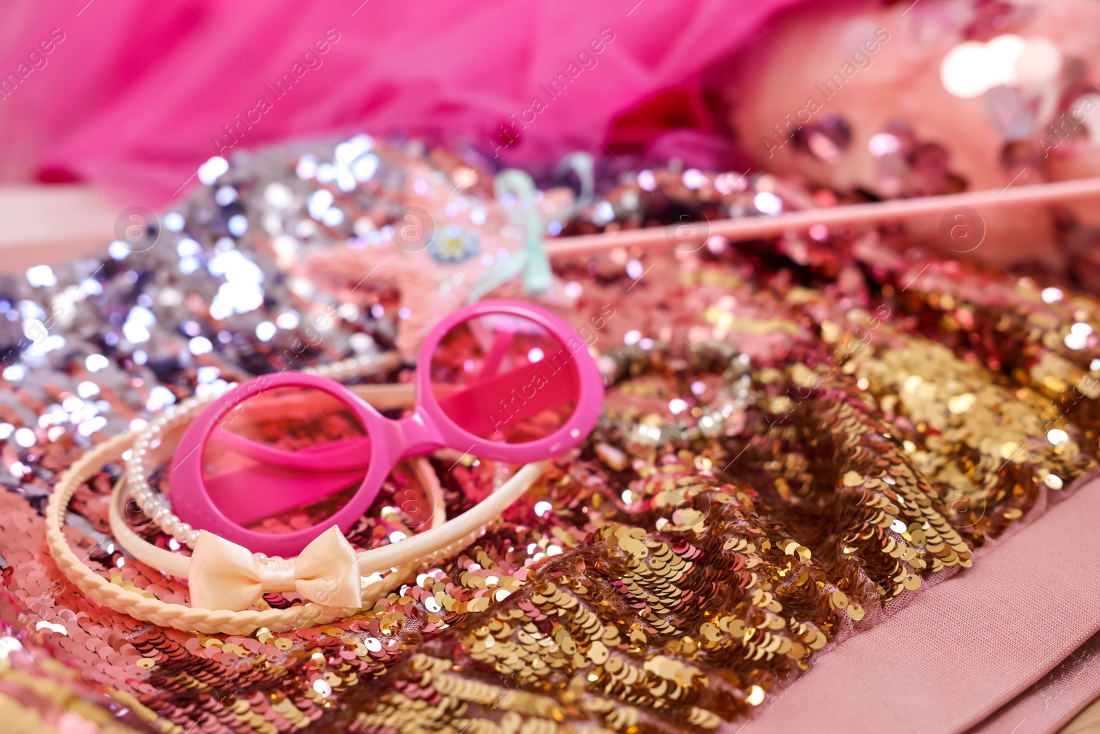 Photo of Stylish carnival costume with sequins, sunglasses, wand and headbands, closeup