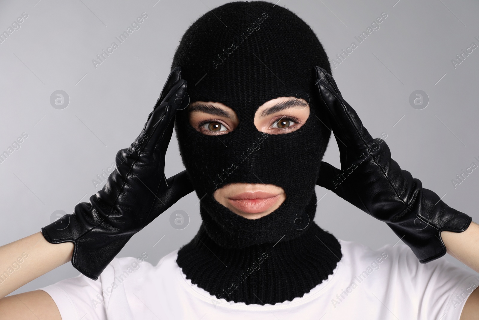 Photo of Woman wearing knitted balaclava on grey background