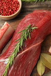 Photo of Raw beef tenderloin and spices on table, closeup