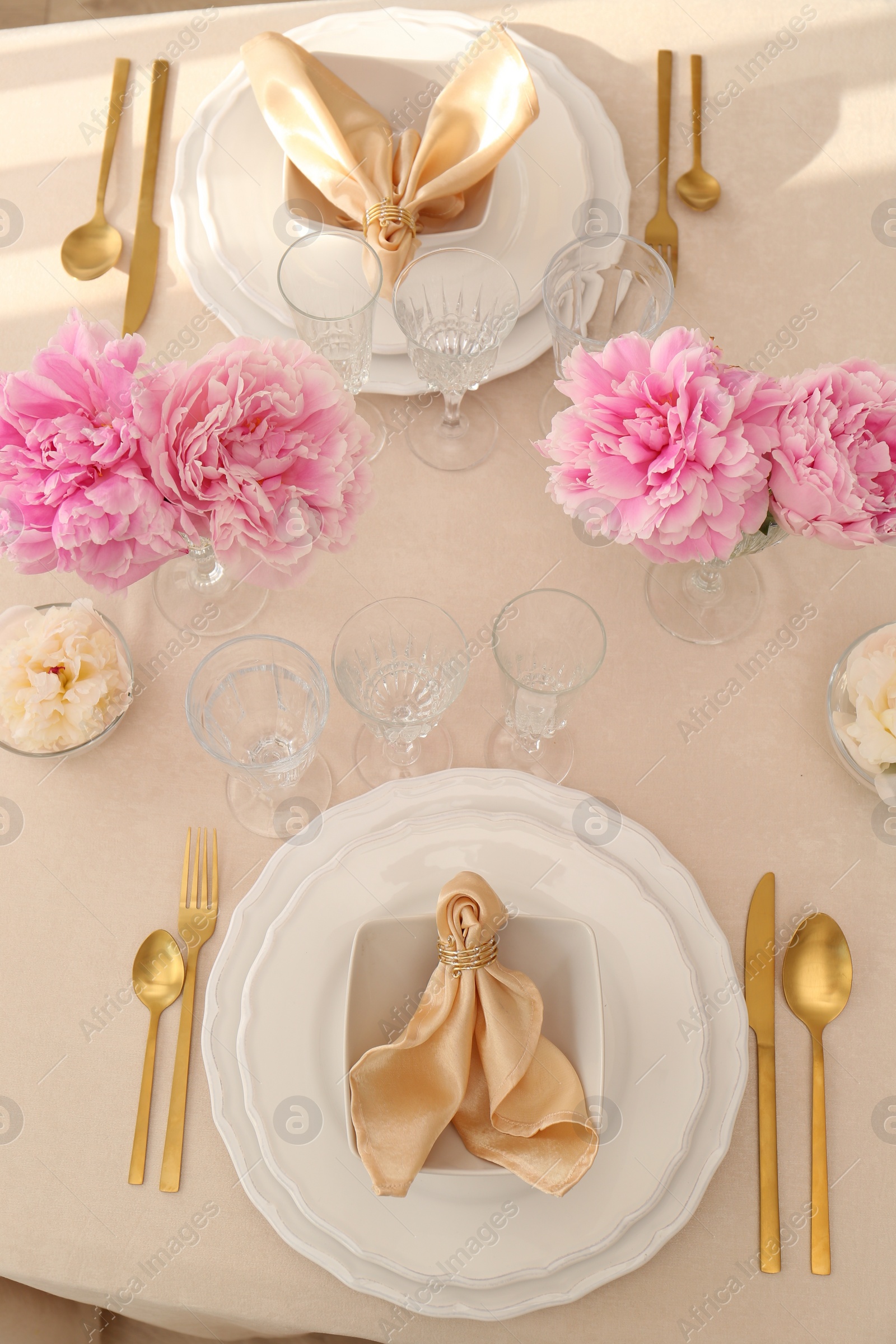 Photo of Stylish table setting with beautiful peonies and fabric napkins, above view