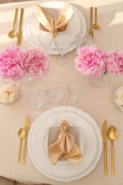 Stylish table setting with beautiful peonies and fabric napkins, above view