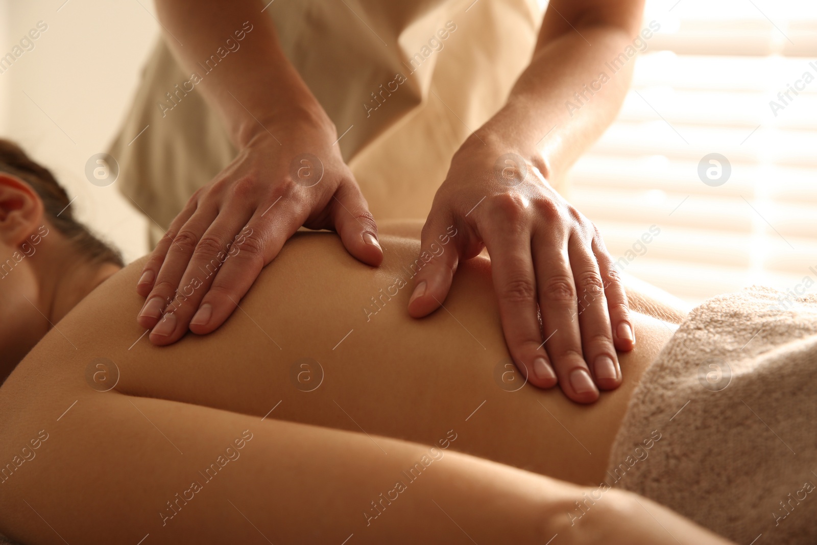 Photo of Young woman receiving back massage in spa salon, closeup