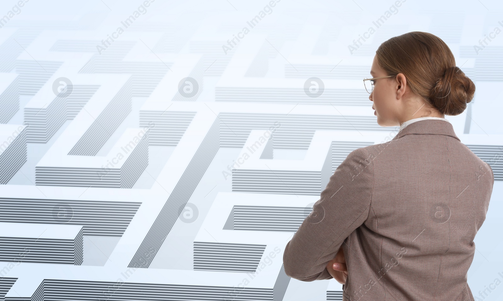 Image of Young businesswoman in suit looking for way out of maze