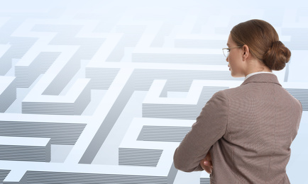 Image of Young businesswoman in suit looking for way out of maze