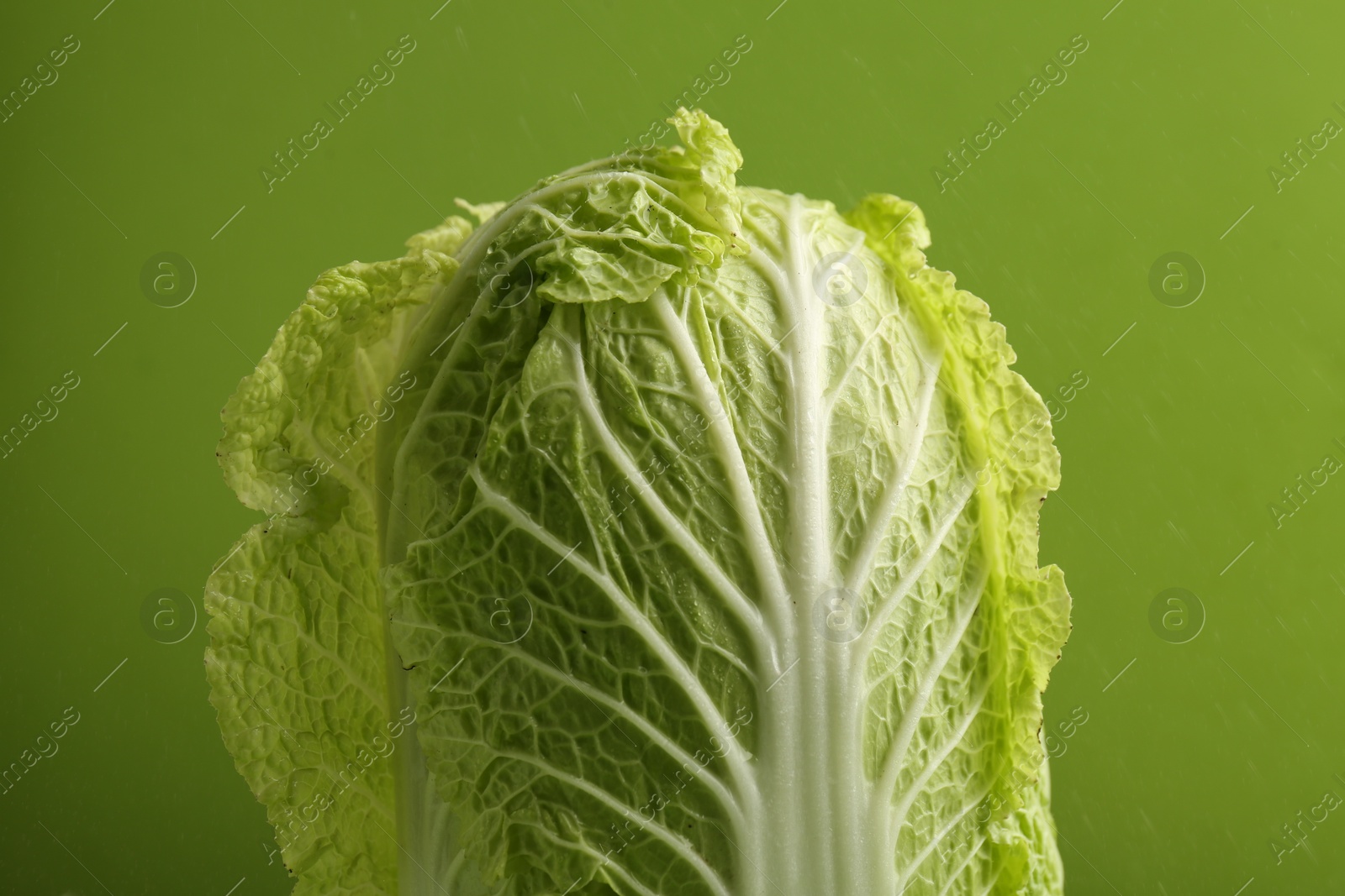 Photo of Fresh ripe Chinese cabbage on light green background, closeup