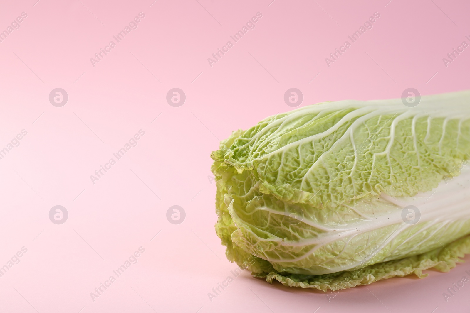 Photo of Fresh ripe Chinese cabbage on pink background, closeup. Space for text