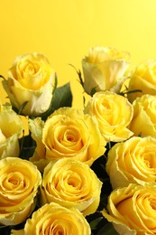 Photo of Beautiful bouquet of roses on yellow background, closeup