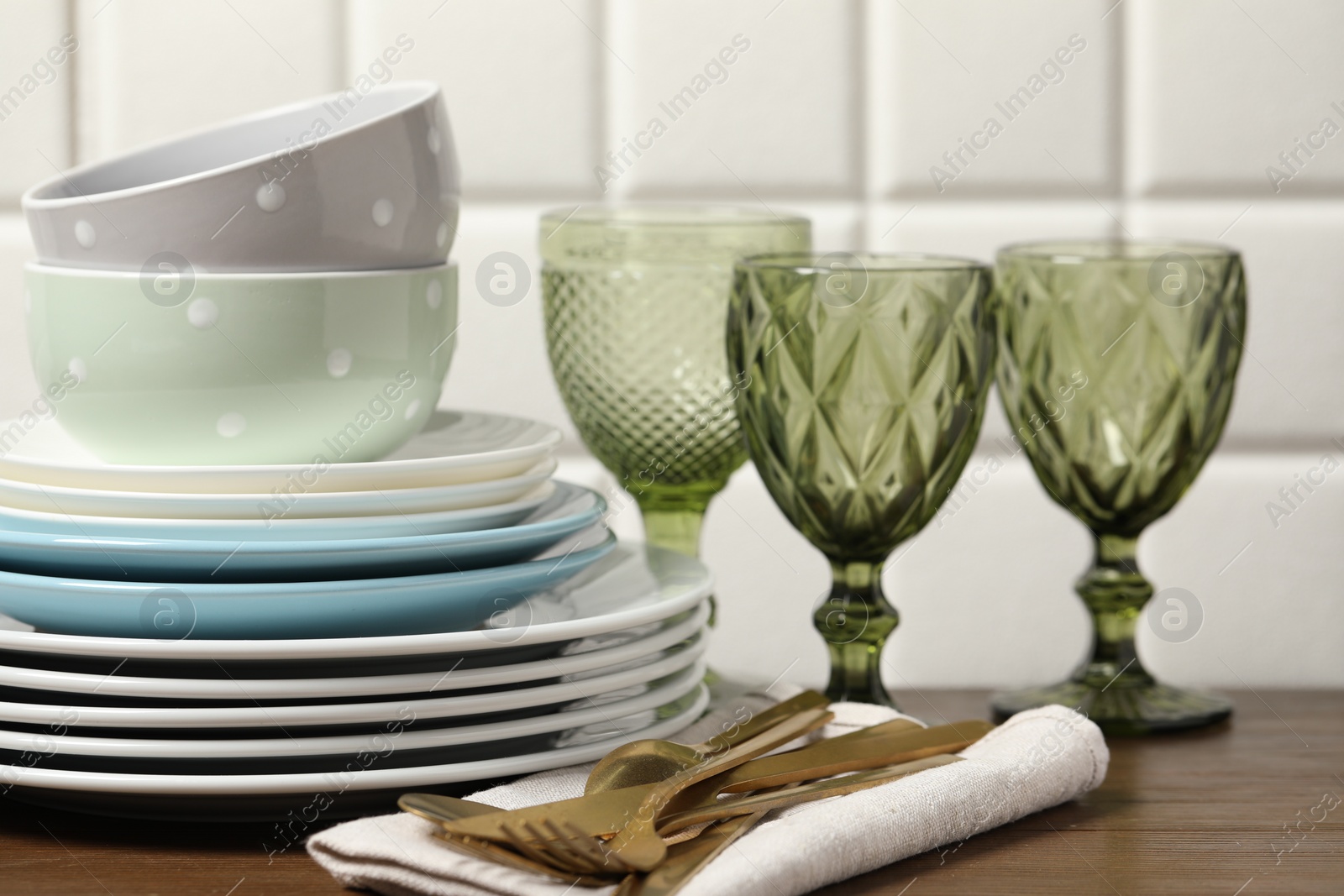 Photo of Beautiful ceramic dishware, glasses and cutlery on wooden table